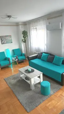 a living room with a blue couch and a table at Dream Rental Pirot Apartman in Pirot