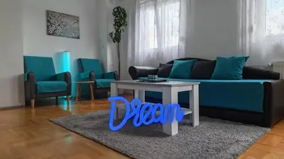 a living room with a blue couch and a table at Dream Rental Pirot Apartman in Pirot