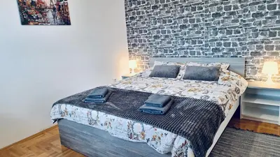 a bedroom with a bed with a brick wall at Dream Rental Pirot Apartman in Pirot