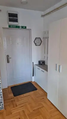 a kitchen with a white door and a wooden floor at Dream Rental Pirot Apartman in Pirot