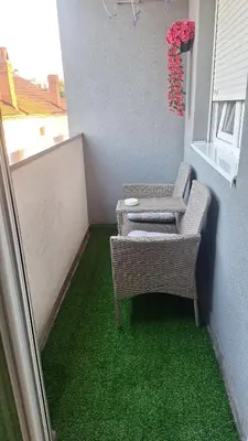 a balcony with a table and chairs and green carpet at Dream Rental Pirot Apartman in Pirot
