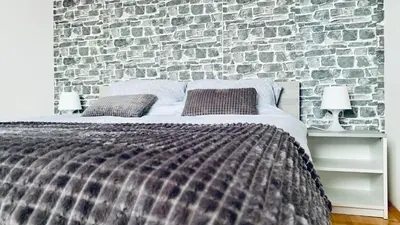 a bed in a room with a brick wall at Dream Rental Pirot Apartman in Pirot