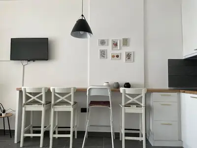 a kitchen with a bar with stools and a tv at Residence Hills Lux Hotels & Spa Kopaonik in Kopaonik