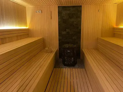 a sauna with two empty saunas and a stone fireplace at Residence Hills Lux Hotels & Spa Kopaonik in Kopaonik