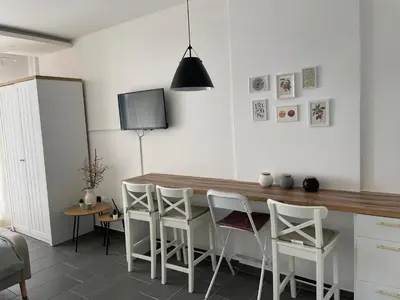 a kitchen with a wooden table and white chairs at Residence Hills Lux Hotels & Spa Kopaonik in Kopaonik