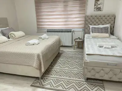 a bedroom with two beds and a window at Apartmani Safir Krusevac in Kruševac
