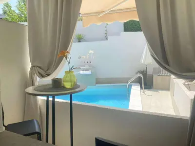 a table with a vase on it next to a swimming pool at Apartmani Safir Krusevac in Kruševac
