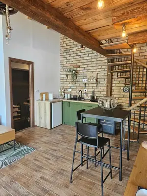 a kitchen with a table and chairs in a room at Bear Secret House in Ćuprija