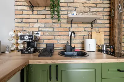 a kitchen with a sink and a brick wall at Bear Secret House in Ćuprija