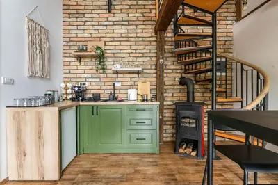a kitchen with a green cabinet and a brick wall at Bear Secret House in Ćuprija