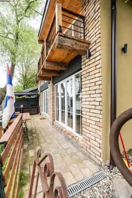 a patio with a wooden bench and a building at Bear Secret House in Ćuprija
