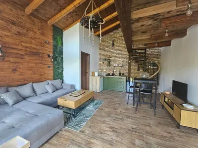 a living room with a couch and a table and a kitchen at Bear Secret House in Ćuprija