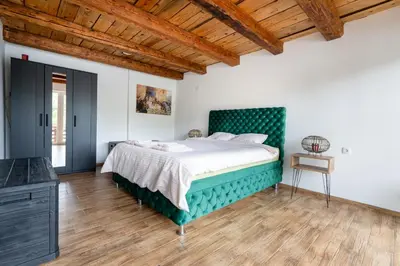a bedroom with a bed with a green headboard at Bear Secret House in Ćuprija