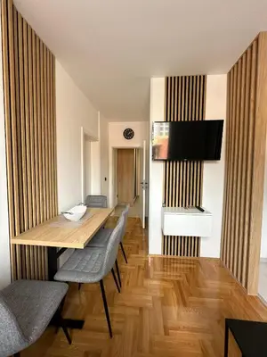 a dining room with a table and chairs and a television at Apartman Iznad Sunca in Soko Banja