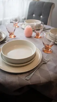 a table with plates and glasses and a pink egg on it at Apartman Emilija i Julija in Soko Banja
