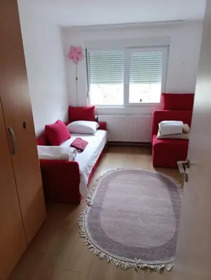 a room with two beds and a couch and a window at Apartman Emilija i Julija in Soko Banja