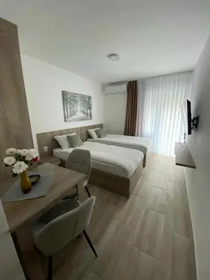 a hotel room with two beds and a table at Smeštaj Gligorijević in Lukovo