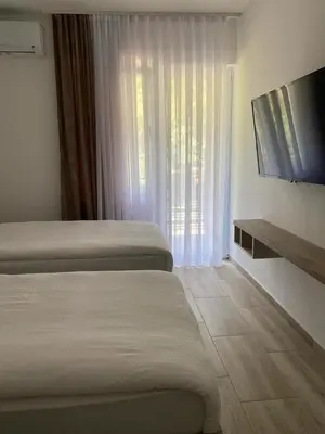 a hotel room with two beds and a flat screen tv at Smeštaj Gligorijević in Lukovo