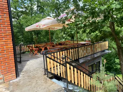 a wooden deck with tables and an umbrella at Ognjište in Prokuplje