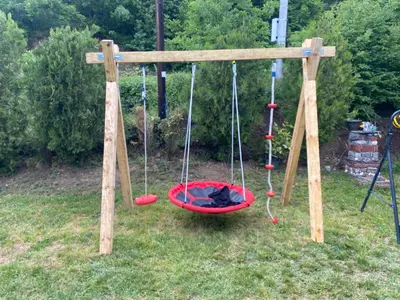 a swing set with three swings in the grass at Ognjište in Prokuplje