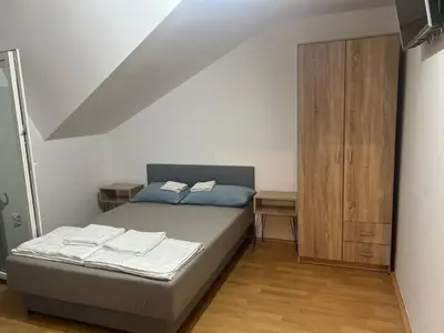 a bedroom with a bed and a wooden cabinet at Vila RUŽA - House of Roses in Soko Banja