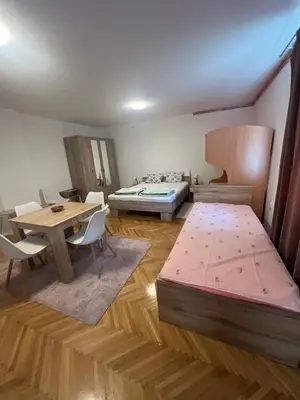 a room with a bed and a table and chairs at Vila RUŽA - House of Roses in Soko Banja