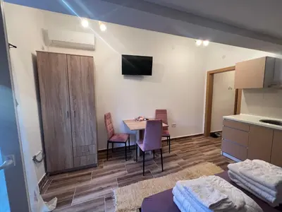 a room with a table and chairs and a kitchen at Vila RUŽA - House of Roses in Soko Banja