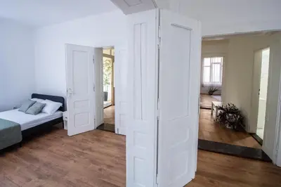 a bedroom with white walls and a bed in a room at Family House in Leskovac