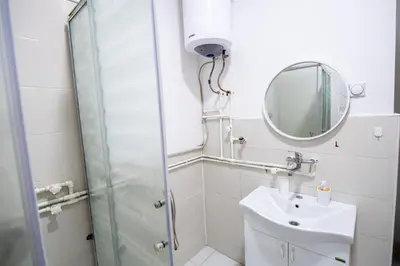 a bathroom with a shower and a sink and a mirror at Family House in Leskovac