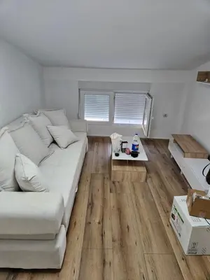 a living room with a large white bed and wooden floors at Oki in Gornje Stopanje