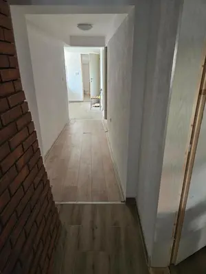 a hallway of a house with a brick wall and wooden floors at Oki in Gornje Stopanje
