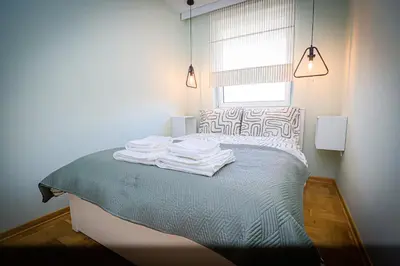 a bedroom with a bed with towels on it at Grey Apartment On the Hill in Vrnjačka Banja