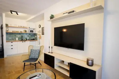 a living room with a large television on a wall at Grey Apartment On the Hill in Vrnjačka Banja