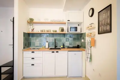 a kitchen with white cabinets and a microwave at Grey Apartment On the Hill in Vrnjačka Banja