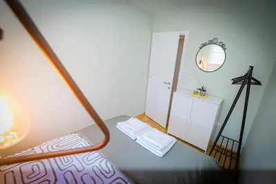 a small bedroom with a bed and a mirror at Grey Apartment On the Hill in Vrnjačka Banja