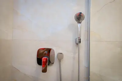 a shower with a shower head on a wall at Grey Apartment On the Hill in Vrnjačka Banja