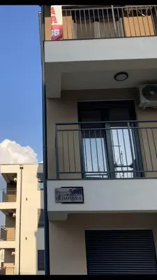 a building with a balcony and a sign on it at Apartman Raj in Vrnjci