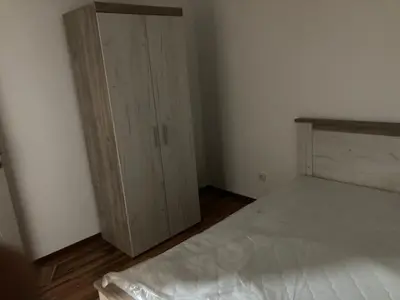 a bedroom with a bed and a wooden cabinet at Apartman Raj in Vrnjci