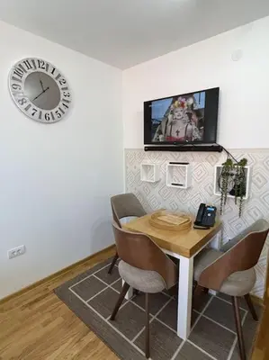 a dining room with a table and a tv on the wall at Ema - Jakov Kopaonik Kraljevi Čardaci in Kopaonik