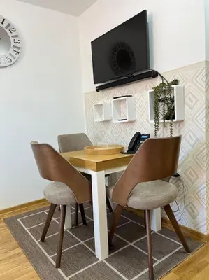 a wooden table with two chairs and a television on a wall at Ema - Jakov Kopaonik Kraljevi Čardaci in Kopaonik