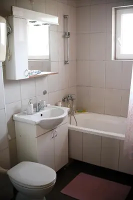 a bathroom with a sink and a toilet and a tub at Apartman LUX*** in Leskovac
