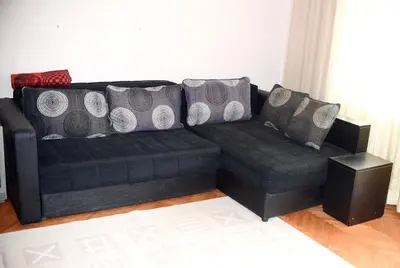 a black couch with pillows on it in a living room at Apartman LUX*** in Leskovac