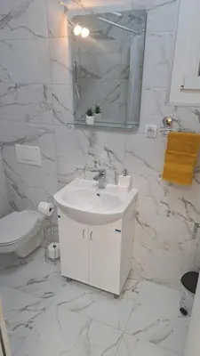 a white bathroom with a sink and a toilet at Vila Jevtić studio 3 in Soko Banja