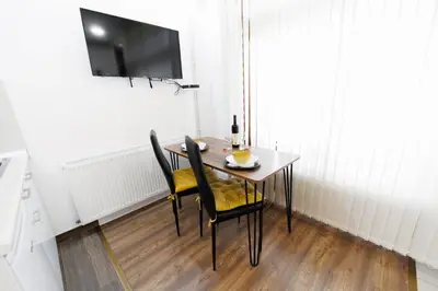 a dining room table with two chairs and a television at Vila Jevtić studio 3 in Soko Banja
