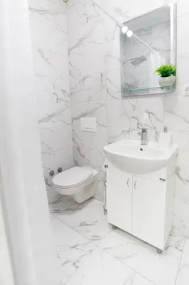 a white bathroom with a sink and a toilet at Vila Jevtić studio 3 in Soko Banja