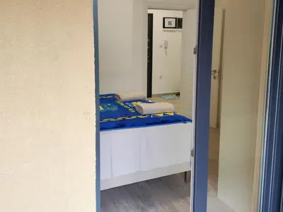 a mirror in a room with a bed at Lacky-ca in Prokuplje
