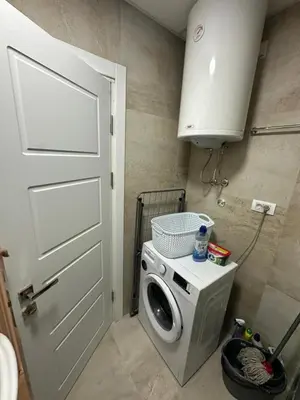 a washing machine in a small room with a door at Lacky-ca in Prokuplje