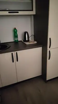 a kitchen with white cabinets and a tea kettle on the counter at Lacky-ca in Prokuplje