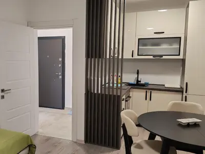 a living room with a table and a kitchen at Lacky-ca in Prokuplje