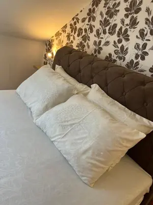 a bed with two white pillows on top of it at Royal suite Nis in Niš